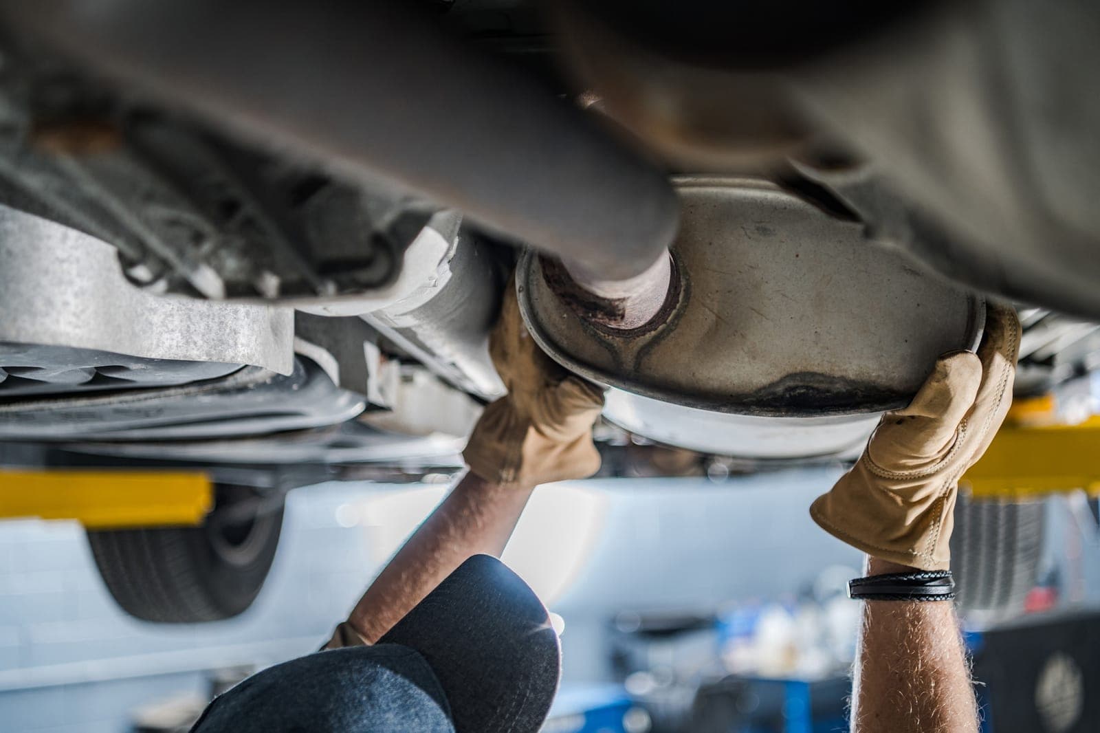Mechanic checking a vehicle exhaust system