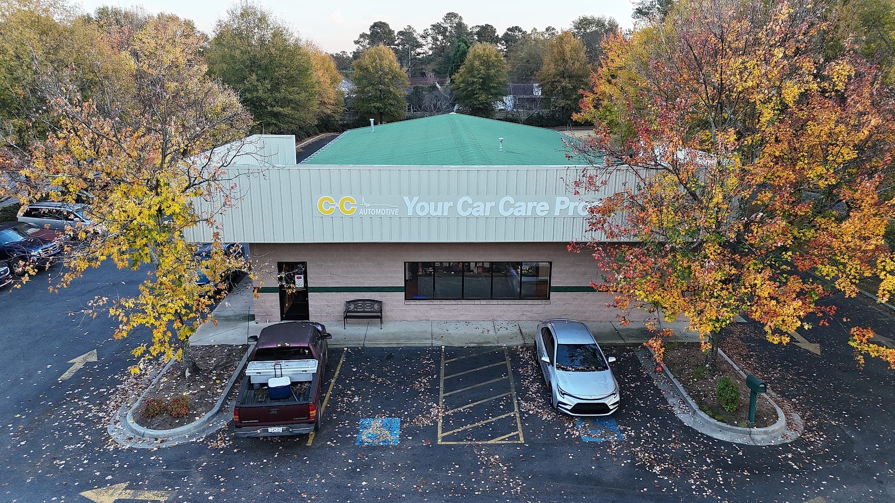 Aerial view of the C&C Automotive Aiken shop on East Pine Log Road, framed by trees in fall color.