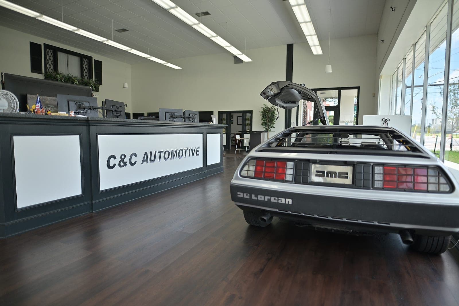 Downtown Augusta showroom with the C&C Automotive front counter and a vintage DeLorean DMC-12 on display.