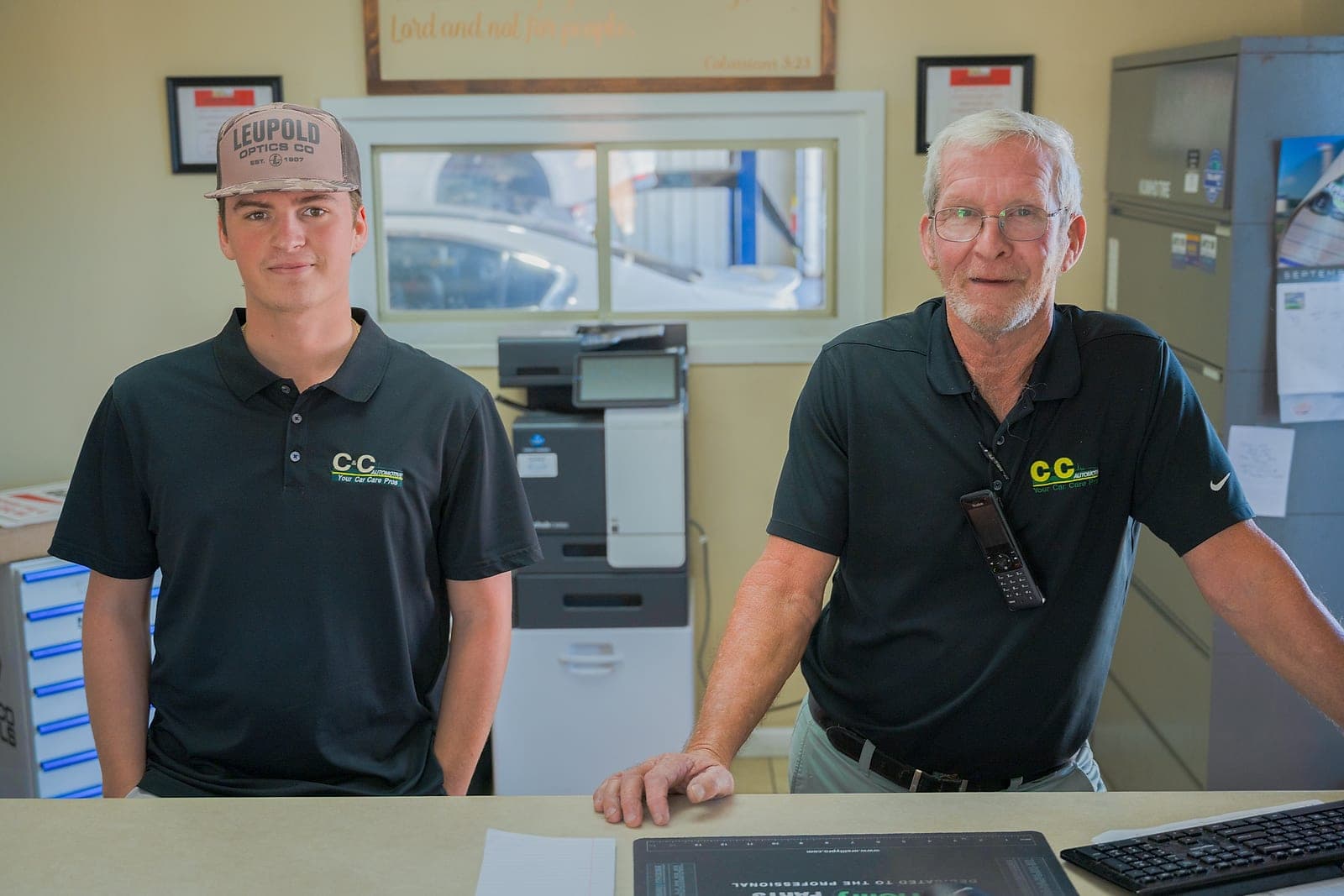 Two C&C Automotive team members behind the front counter at the Thomson shop, ready to help customers.