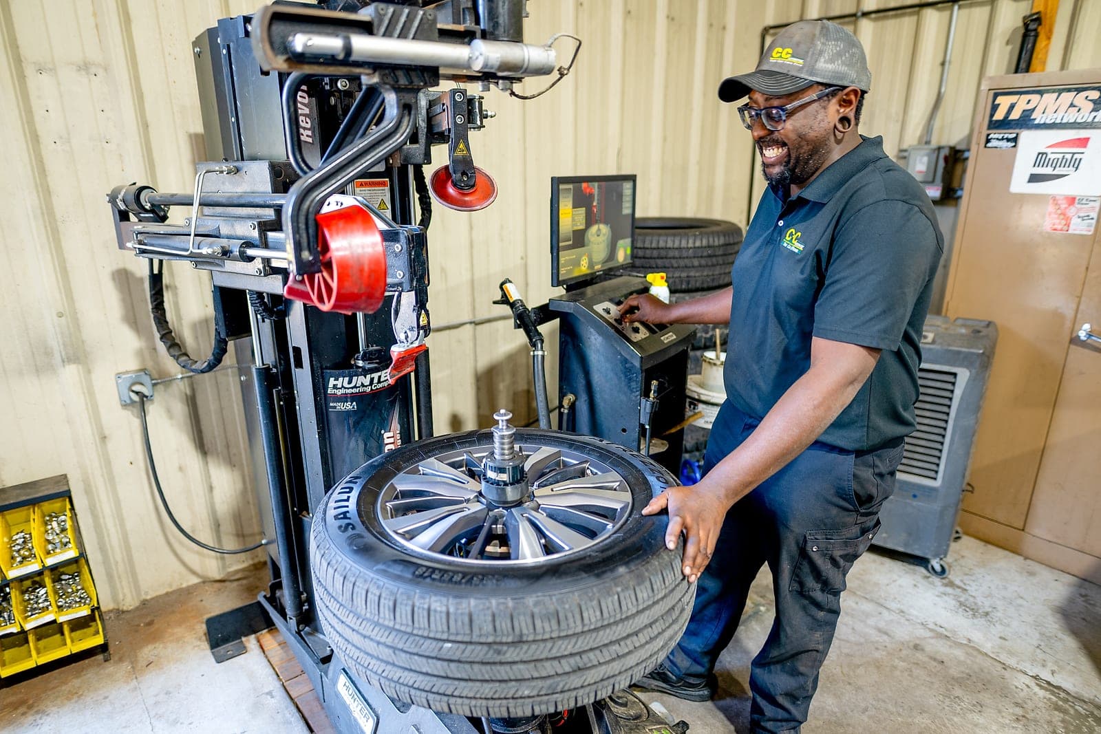 C&C Automotive technician mounting a new tire on a Hunter tire machine at the Thomson shop.