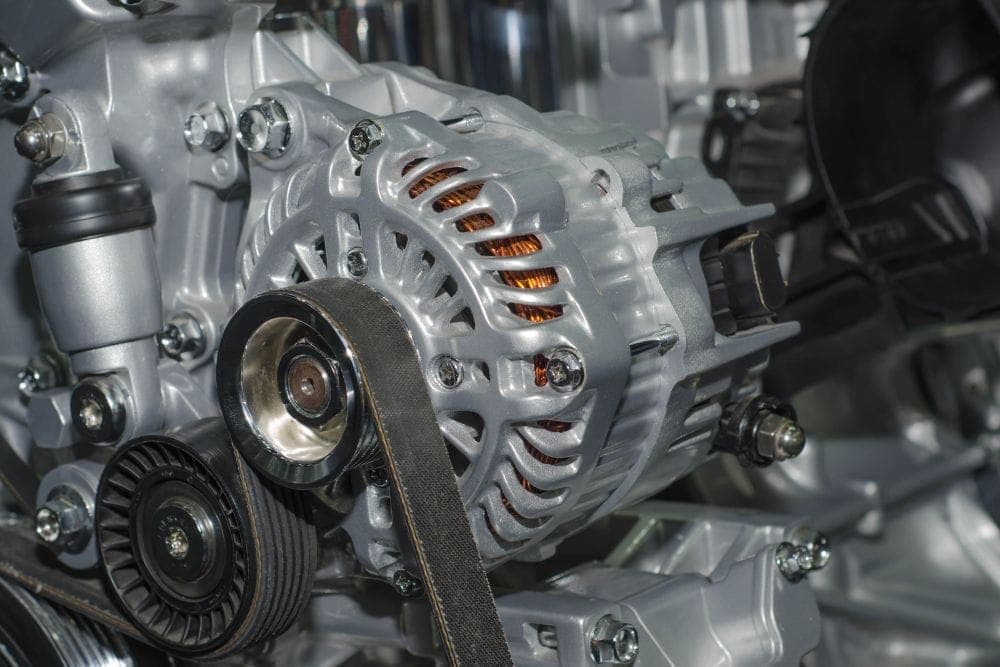 Vehicle alternator being inspected by a technician