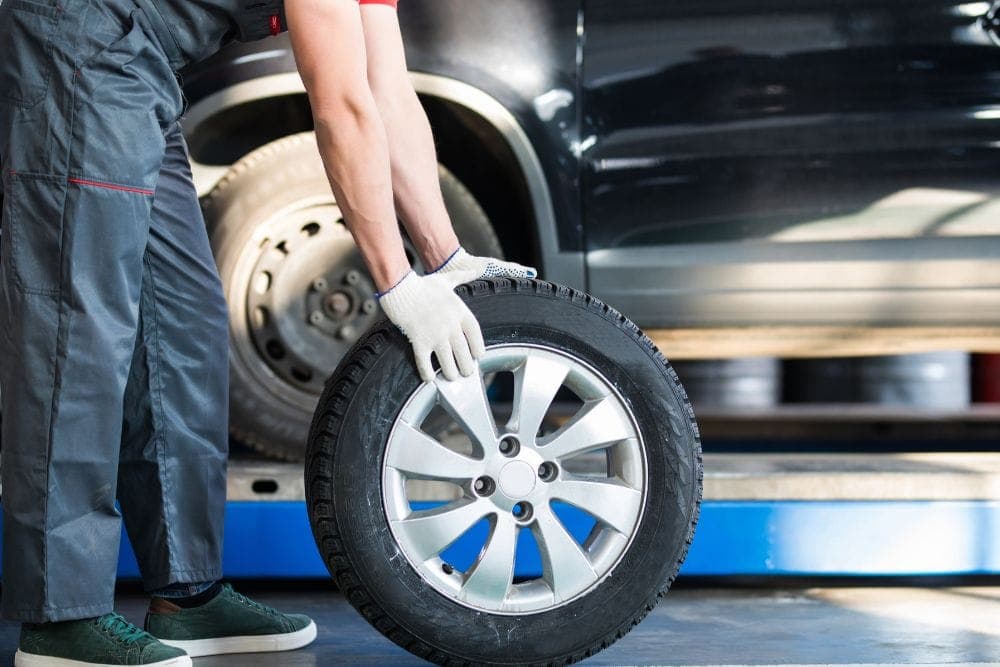 Tire being inspected for wear and damage after winter
