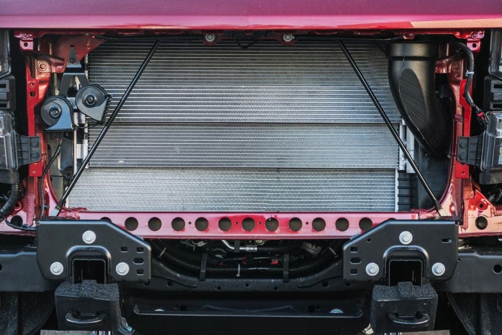 Mechanic servicing a car radiator before winter
