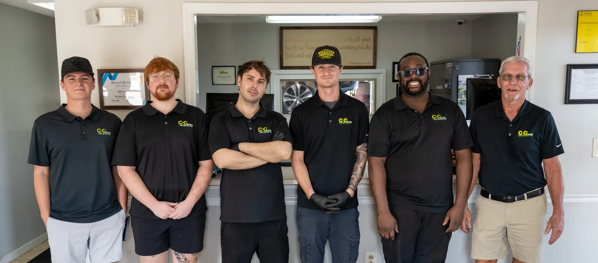 The six-person C&C Automotive Thomson crew standing together at the shop's front counter in their black shop polos
